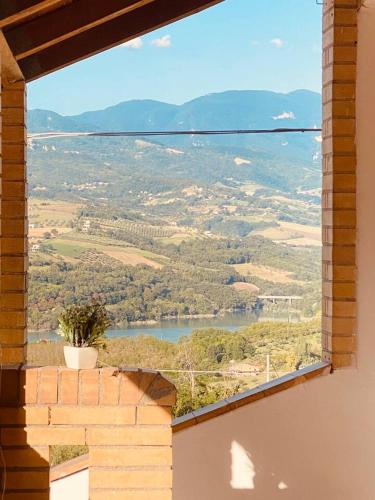 a window in a brick building looking out at a lake at Matteo's House in Penne