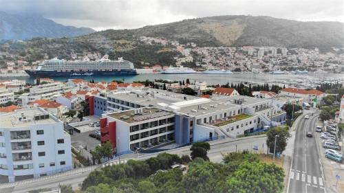 a city with a cruise ship in a harbor at Hotel D'Elegant Dubrovnik in Dubrovnik