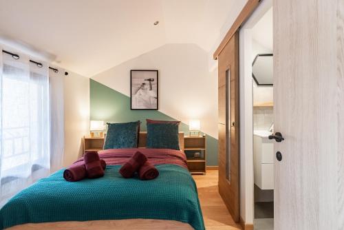 - une chambre avec un grand lit et une couverture verte dans l'établissement Charmante Maison Climatisée avec son Jardin à 10 minutes de DIJON, à Marsannay-la-Côte