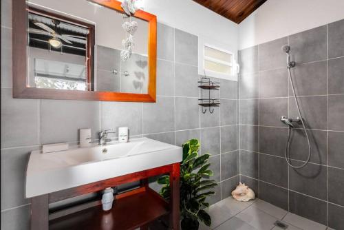 een badkamer met een wastafel en een douche bij Alizé in Sainte-Luce