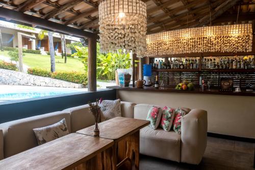 a bar with a bench and a table and chairs at Hotel Villaggio Tudo Bom in Uruau