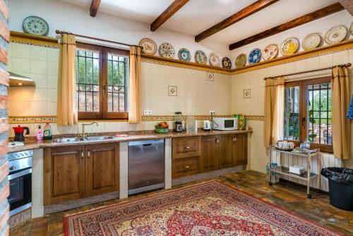 a large kitchen with wooden cabinets and a rug at Villa San Nicolas - private, tranquil, relaxing.. in Ermita Nueva