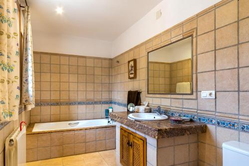 a bathroom with a tub and a sink and a mirror at Villa San Nicolas - private, tranquil, relaxing.. in Ermita Nueva