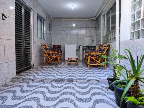 a balcony with two chairs and a table on a floor at Pousada Guarulhos in Guarulhos