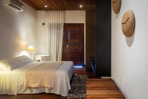 a bedroom with a bed and a hallway with a door at Hotel Villaggio Tudo Bom in Uruau