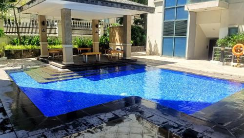 uma piscina no meio de uma casa com água azul em Hilander's Condotel near Terminal 3 Airport em Manila