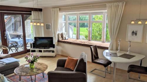 a living room with a couch and a tv at Rosenhof12 in Büsumer Deichhausen