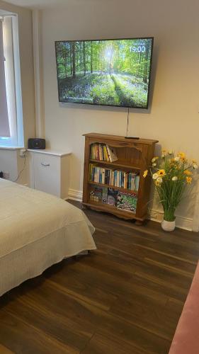 a bedroom with a bed and a flat screen tv on the wall at Bexhill Beautiful Sea Front Bungalow in Bexhill