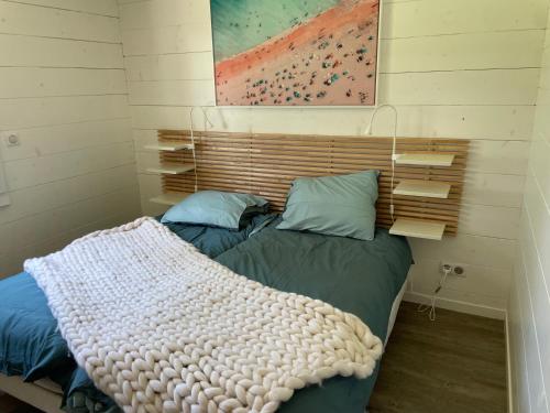 ein Schlafzimmer mit einem Bett mit einer Decke darauf in der Unterkunft CHEZ NOUNOU in Souvans