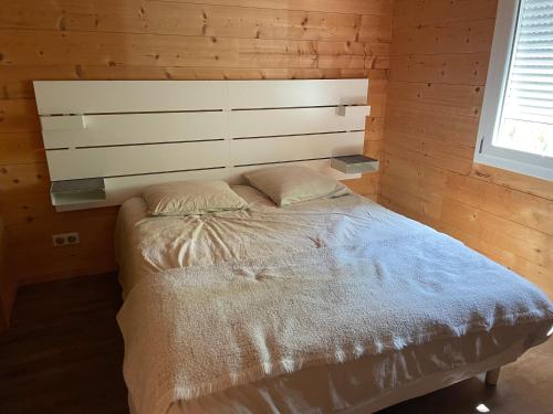 uma cama num quarto com uma parede de madeira em CHEZ NOUNOU em Souvans