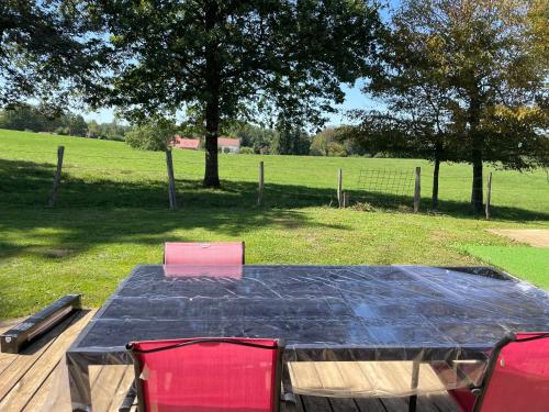 a table with red chairs and a black table cloth at CHEZ NOUNOU in Souvans