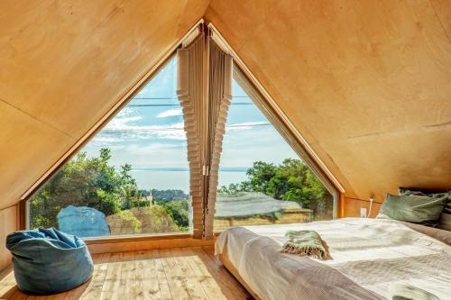 Cama en habitación con ventana grande en Kőház a Hegyen, en Badacsonytomaj