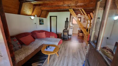 ein Wohnzimmer mit einem roten Sofa und einem Tisch in der Unterkunft Planinska Kuća Dušan in Mitrovac