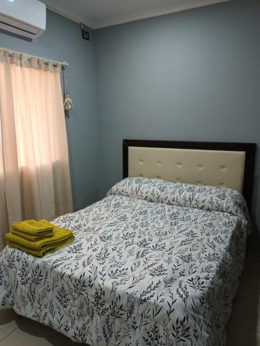 1 dormitorio con 1 cama con edredón blanco y negro en Departamento en Ciudad De La Punta en La Punta