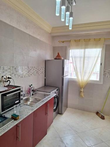 uma cozinha com um frigorífico, um lavatório e uma janela em Appartement à Agadir em Agadir