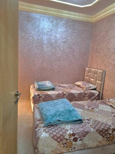 um quarto com duas camas com almofadas azuis em Appartement à Agadir em Agadir