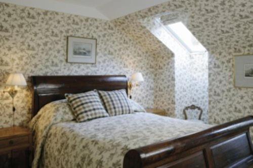 a bedroom with a bed and two lamps and a window at Hotel Frederiksminde in Præstø