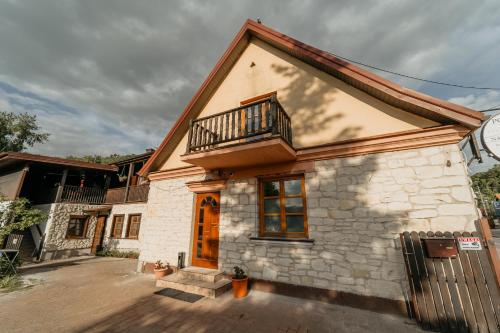 een huis met een balkon er bovenop bij Pokoje gościnne Nadrzeczna in Kazimierz Dolny