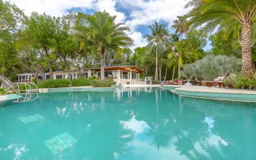 una piscina con palmeras y una casa en Largo Resort, en Cayo Largo