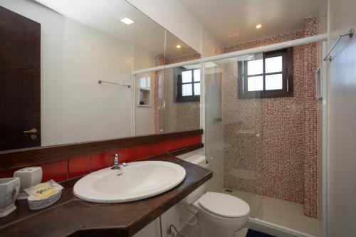 a bathroom with a sink and a toilet and a shower at Casa com Vista Mar e 2 Suítes | CBR 07 in Búzios