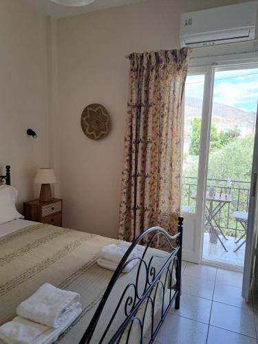 a bedroom with a bed and a window with a balcony at Penny's Beach Cottage in Galaxidi