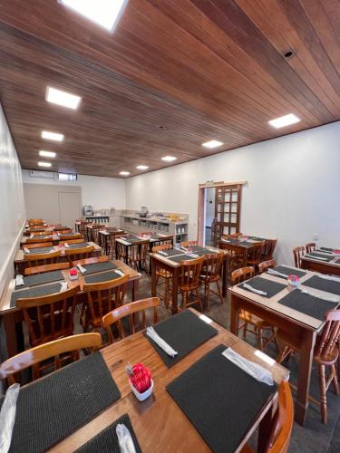 uma sala de aula vazia com mesas e cadeiras de madeira em Hotel Somensi em Bento Gonçalves