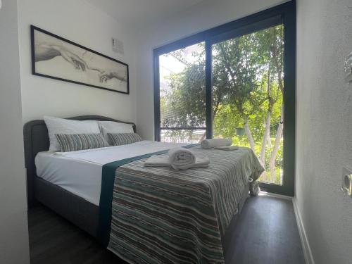 1 dormitorio con cama y ventana grande en KAĞAN Holiday Apartments, en Kemer