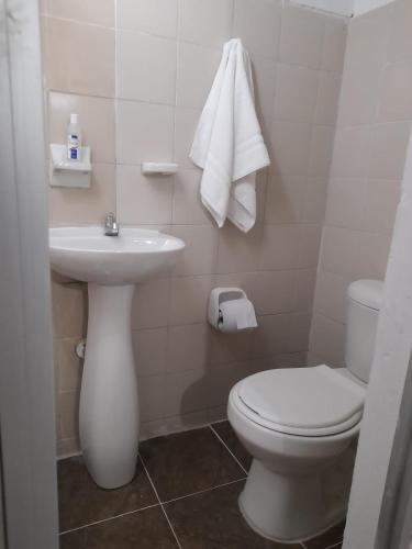 a white bathroom with a toilet and a sink at Apartamento la 20 in Pereira