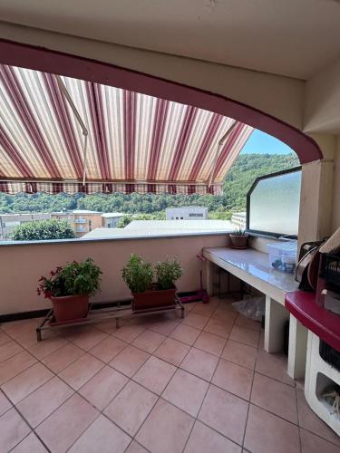 a balcony with potted plants and a large window at Otto Marzo in Finale Ligure