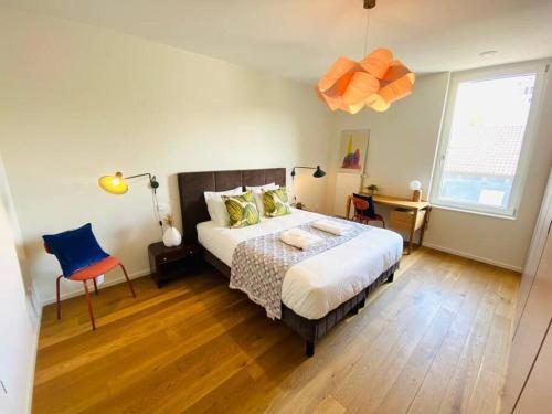 een slaapkamer met een bed, een stoel en een raam bij Luxury 2 bedrooms in Limpertsberg - 61 in Luxemburg
