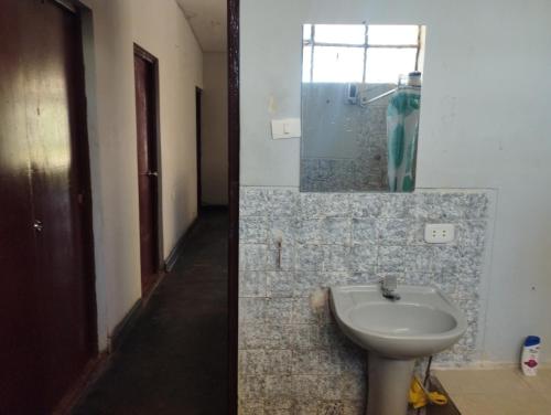 a bathroom with a sink and a mirror at Hospedaje Cora in Piura