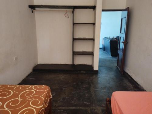 an empty room with a ladder and a door at Hospedaje Cora in Piura