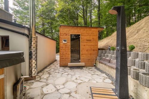 a small brick building with a shower in a yard at Wellness chata Chalet de Glatz in Komorní Lhotka