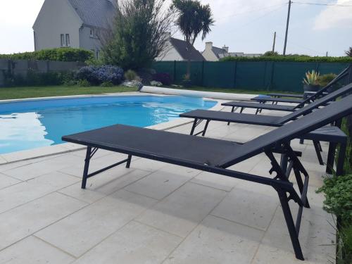 - une table de pique-nique à côté de la piscine dans l'établissement VILLA 5 CHBRES AVEC PISCINE CHAUFFEE A 300M DE LA MER, à Penmarcʼh