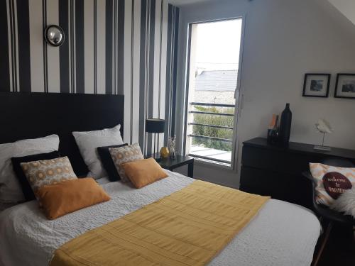 une chambre avec un grand lit et une fenêtre dans l'établissement VILLA 5 CHBRES AVEC PISCINE CHAUFFEE A 300M DE LA MER, à Penmarcʼh