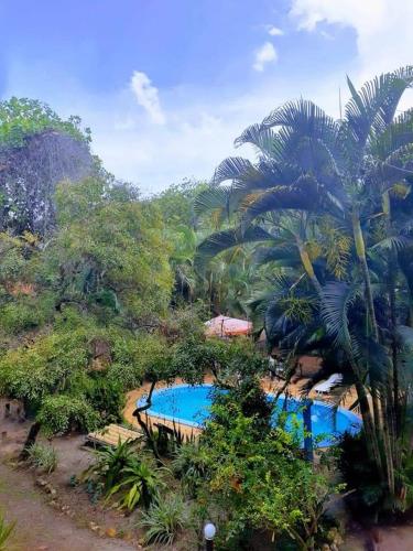 a resort with two swimming pools and palm trees at Pousada Cajibá Imbassaí in Imbassai