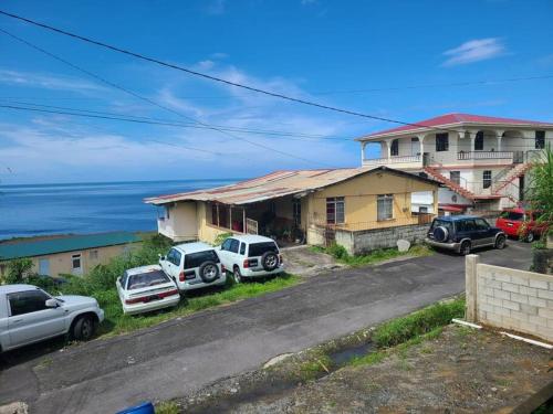 un grupo de autos estacionados frente a una casa en Lovely and cozy 2 bedroom apt with oceanic view, en Roger