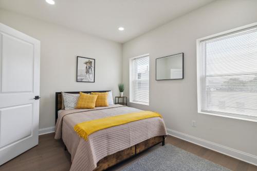 um quarto com uma cama com um cobertor amarelo em Modern City living em Filadélfia