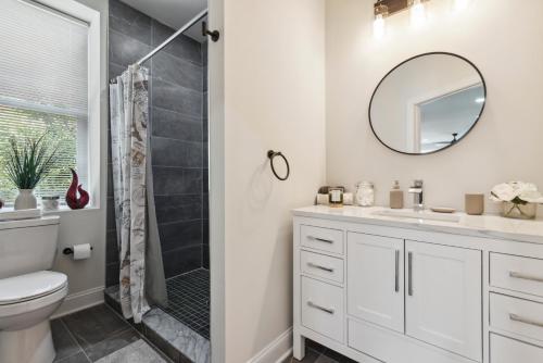 費城的住宿－Modern City living，一间带卫生间、水槽和镜子的浴室