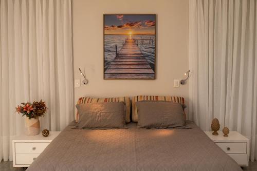um quarto com uma cama e um quadro na parede em Casa 4 Suítes - Ilha do Boi em Vitória