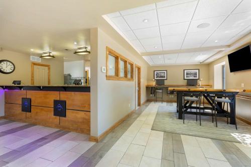 a living room with a table and a tv at Best Western Plus Clocktower Inn in Billings