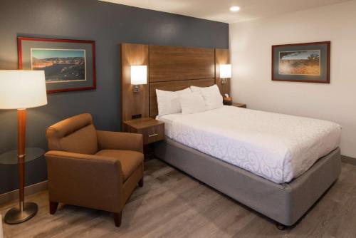 Habitación de hotel con cama y silla en Best Western Plus Clocktower Inn, en Billings