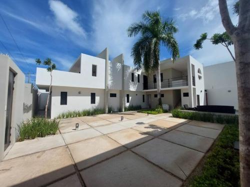ein weißes Haus mit einer Palme davor in der Unterkunft Casa Belcher (Ray's) in Cozumel