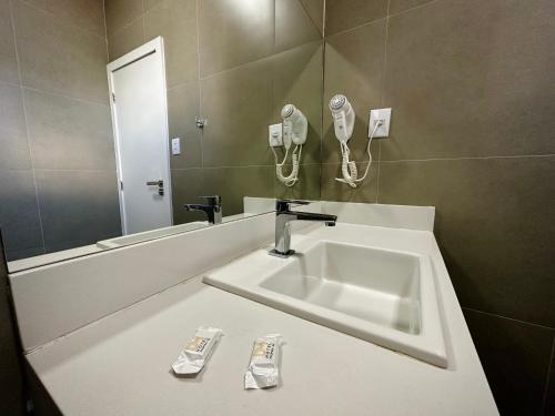 La salle de bains est pourvue d'un lavabo et d'un miroir. dans l'établissement DM HOTEL, à Propriá