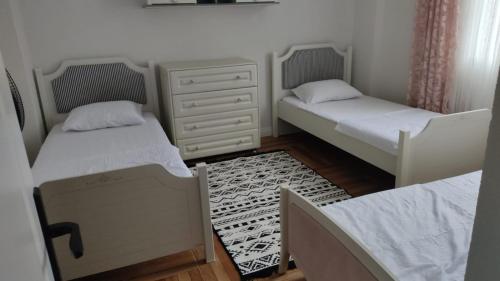 a room with two beds and a dresser at Müstakil Villa Dairesi in Kavala