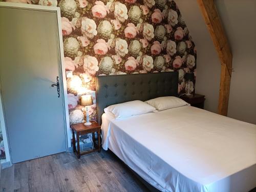 ein Schlafzimmer mit einem Bett und einer Blumenwand in der Unterkunft La Villa Perigourdine in Sarlat-la-Canéda