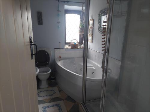a bathroom with a bath tub and a toilet at Charming 2-Bed Cottage in Hebden Bridge in Hebden Bridge