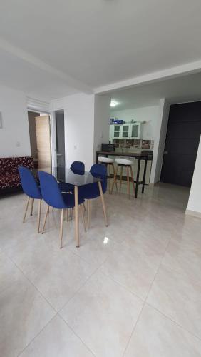 a dining room with blue chairs and a table at Alojamiento Ricaurte Piso 6 in Ricaurte