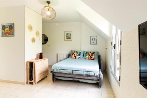 Un dormitorio con una cama con almohadas de colores. en Le Bienvenue, en Bussy-Saint-Georges