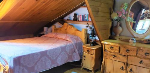 um quarto com uma cama e uma estante de livros em Casa da Rústica em Atalaia de Cima